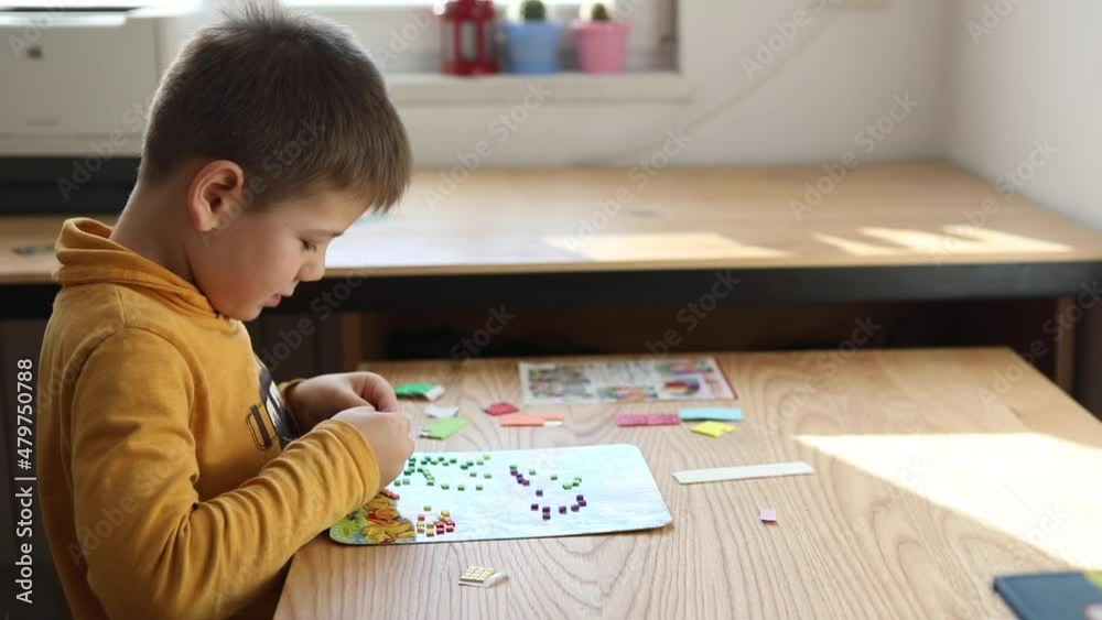 Little boy being creative making homemade do it yourself dinosaur mosaic. Little boy being creative making homemade do it yourself dinosaur mosaic.