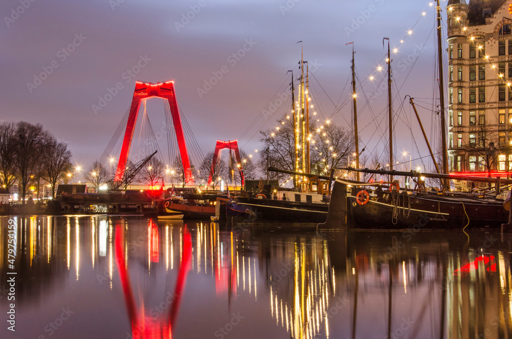 Rotterdam, The Netherlands, January 7, 2022: early morning at the Old Harbour, with historic barges, Willems bridge and the facade of the White House