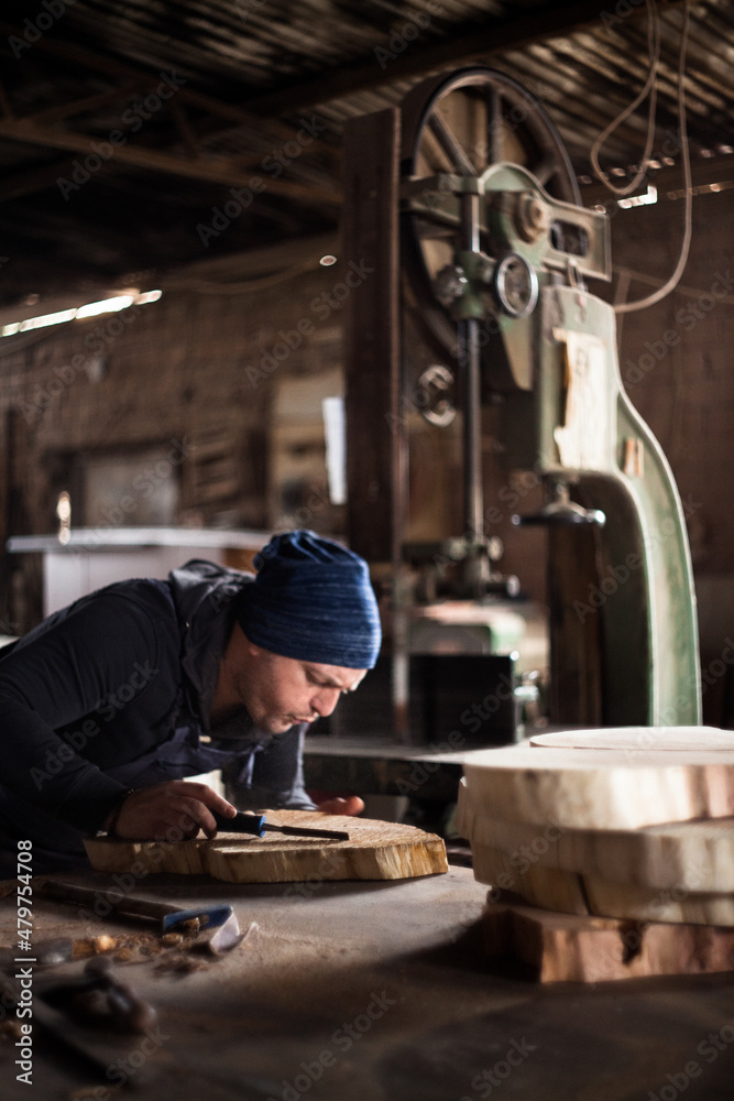 Young male carpenter working in his workshop using tools Young male carpenter working in his workshop using tools