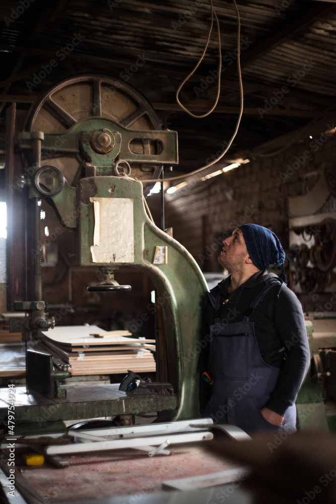 Young male carpenter standing in his work shop