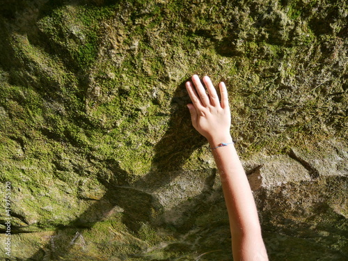 hand of a child on a rock wall