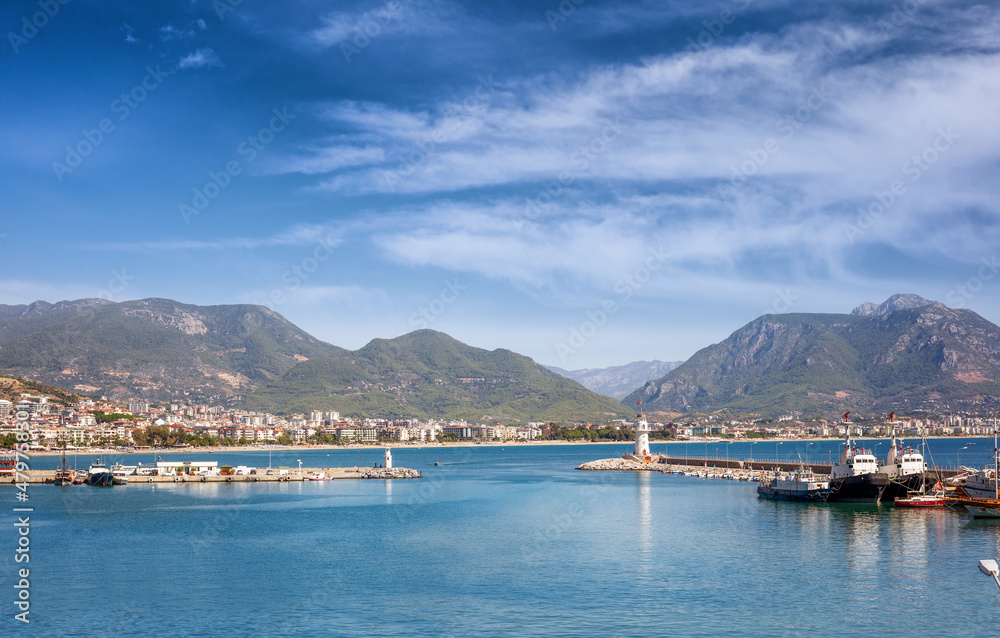 Lighthouse in the port and city view of Alanya, Turkey. Beautiful seascape, summer travel to Turkey