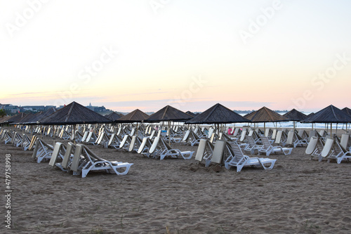 rows of sunbeds on beach without people in early morning.