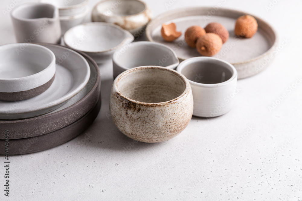 Handmade ceramic tableware, empty craft ceramic on a light background. Clay  plates and cups foto de Stock | Adobe Stock
