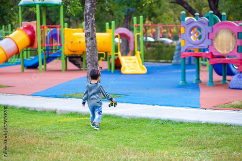 Happy asian boy play truck toy in outdoor playground park photo