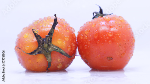 two fresh orange tomatoes on white background