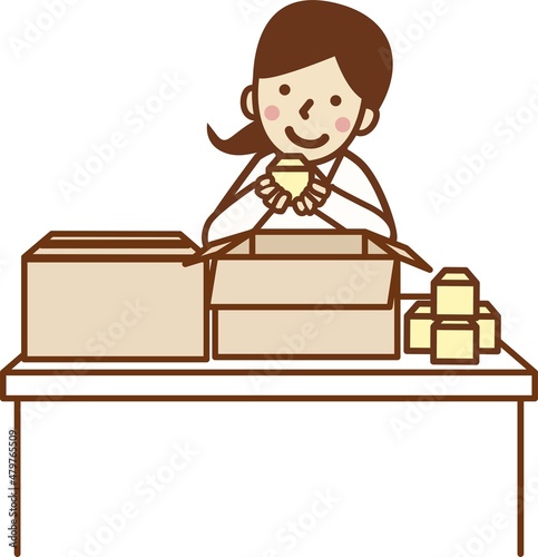 商品を持って作業する女性。