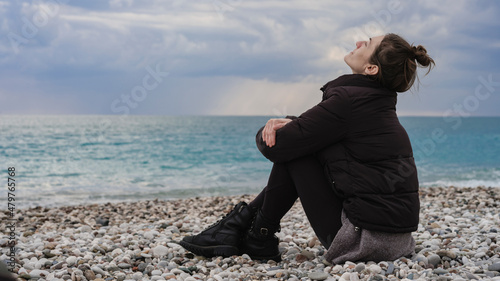 portrait of a woman sitting peacefully on the beach