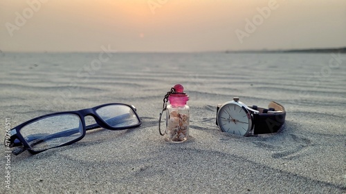 Glasses and hand watch on the beach