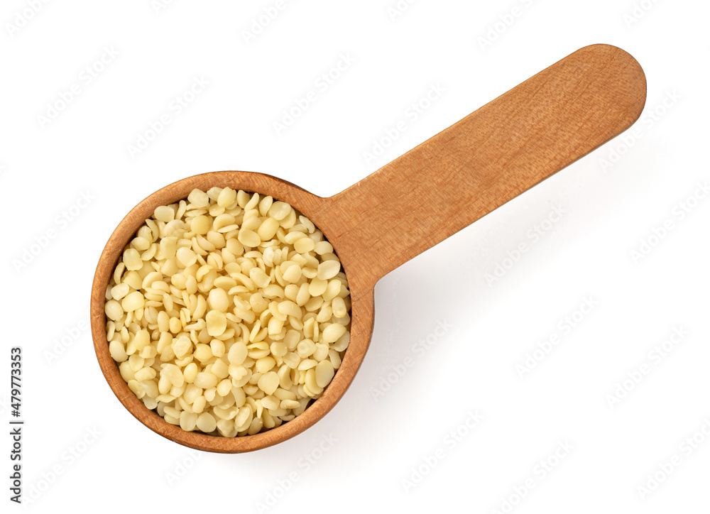 Hulled hemp seeds in the wooden spoon, isolated on white background, top view Hulled hemp seeds in the wooden spoon, isolated on white background, top view