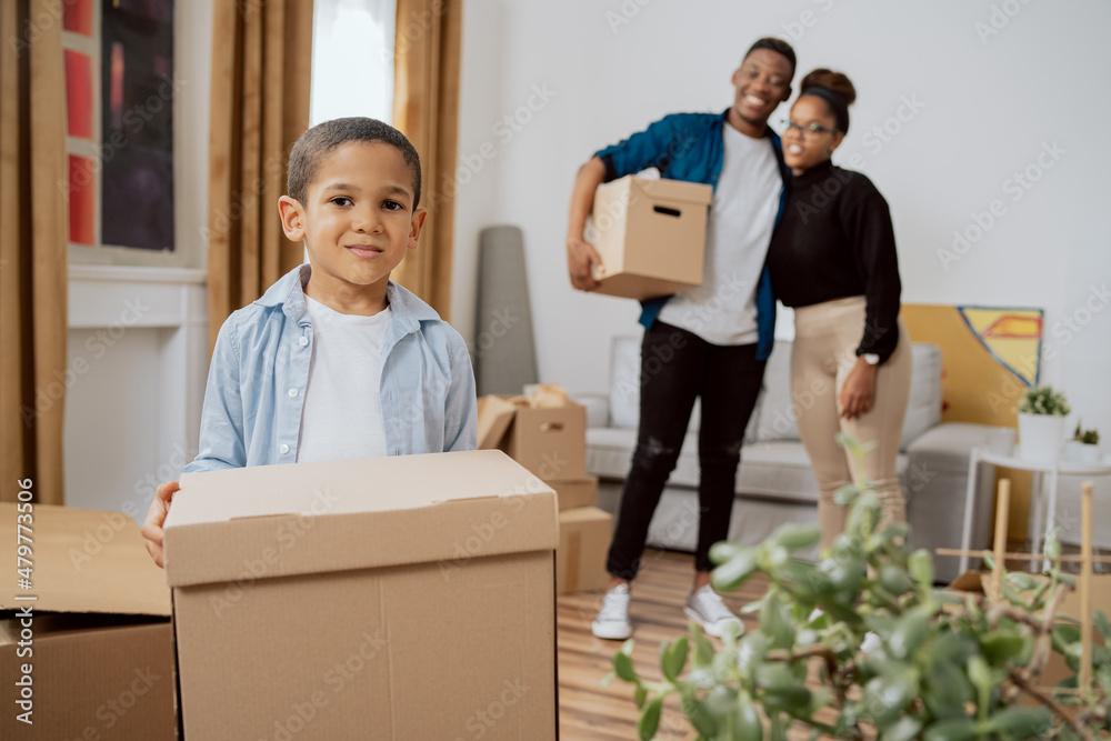 Foto de A young child bravely helps parents carry their packed ...