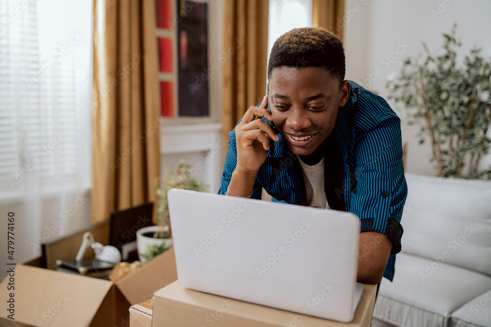 A man has moved into a new apartment, buys furniture online, searches for furnishing stores on his laptop, calls a hotline on the phone to find out more information A man has moved into a new apartment, buys furniture online, searches for furnishing stores on his laptop, calls a hotline on the phone to find out more information