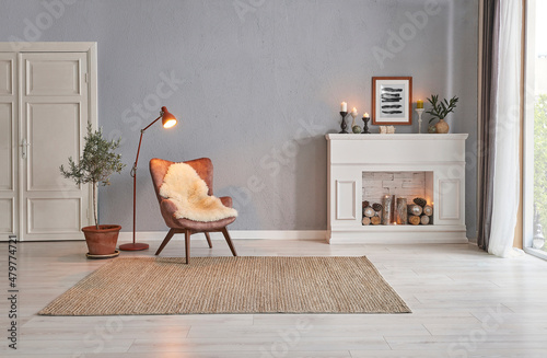 Fotografia, Obraz Modern room concept interior style, chair fireplace frame wicker carpet decoration, grey stone wall background