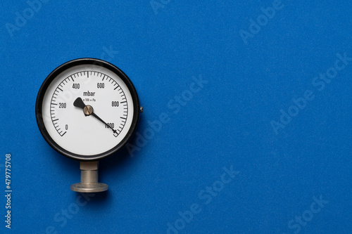 close up of pressure gauge on blue table background, engineering equipment concept
