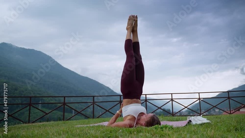 Girl practicing yoga and doing shoulderstand photo