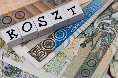 The wording "Koszt" translated as "Cost" and many Polish banknotes. New taxation rules in Poland. Photo taken under artificial, soft light