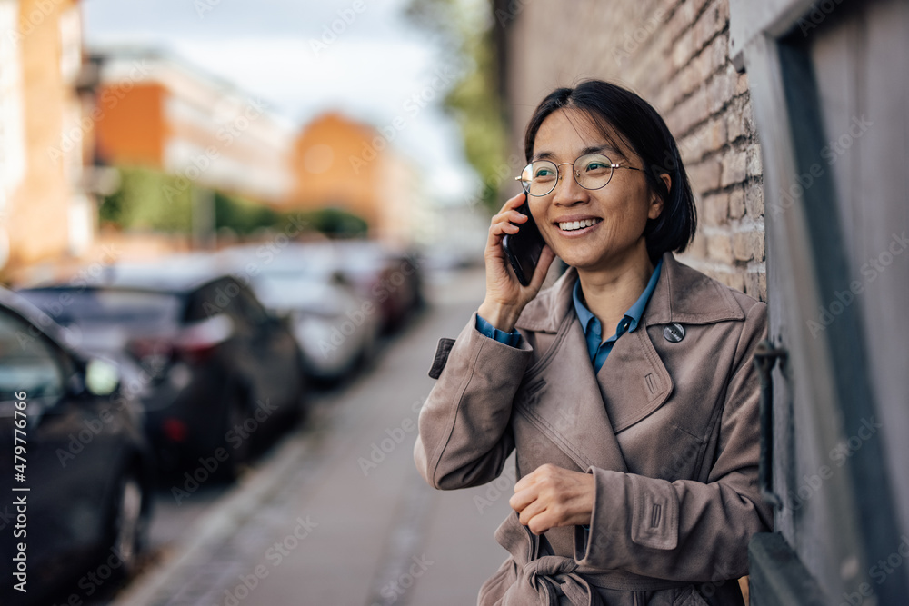 Smiling Asian woman talking on smartphone. Smiling Asian woman talking on smartphone.