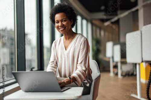 Vászonkép Portrait of delighted african-american woman, working in the modern office