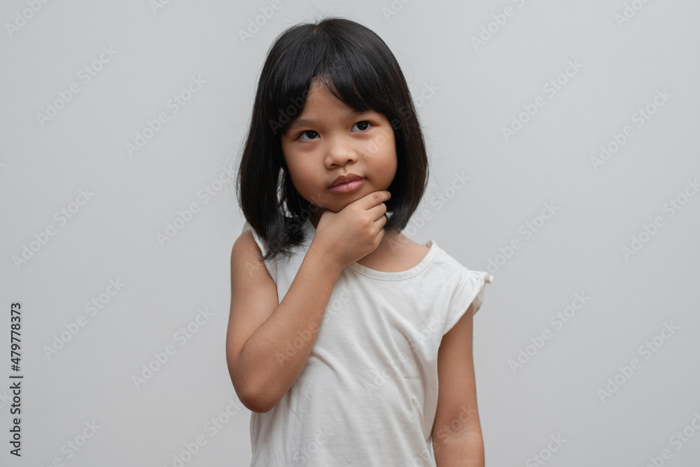 Portrait of Asian child 5 year old and to collect hair and Place her hands on her chin and make thinking pose on isolated white background, She is Happiness, radiance in youth, Education Concept Portrait of Asian child 5 year old and to collect hair and Place her hands on her chin and make thinking pose on isolated white background, She is Happiness, radiance in youth, Education Concept