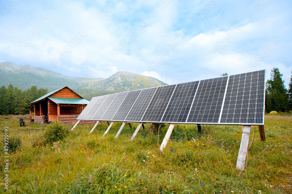 Scandinavian country cottage with solar panels surrounded by mountains, autonomous life