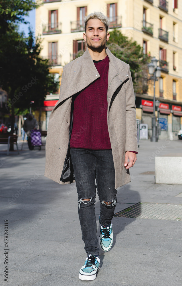 Fashion young model with grey jacket and red sweater in the street 