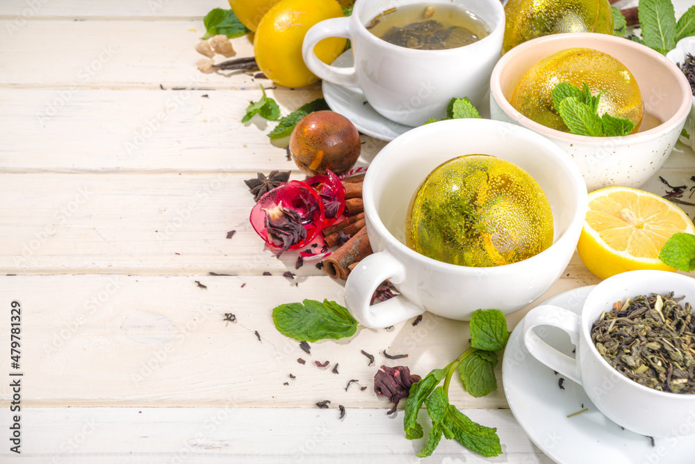 Various tea ball bombs. Assortment of different tea balls with dried tea, cups, lemon and mint, top view copy space. Trendy modern tea variety Various tea ball bombs. Assortment of different tea balls with dried tea, cups, lemon and mint, top view copy space. Trendy modern tea variety