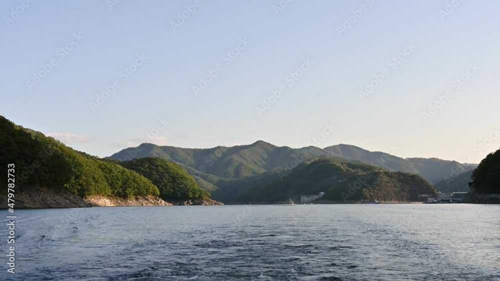 Cruising in Soyang Dam with mountain range and blue sky in the evening Cruising in Soyang Dam with mountain range and blue sky in the evening