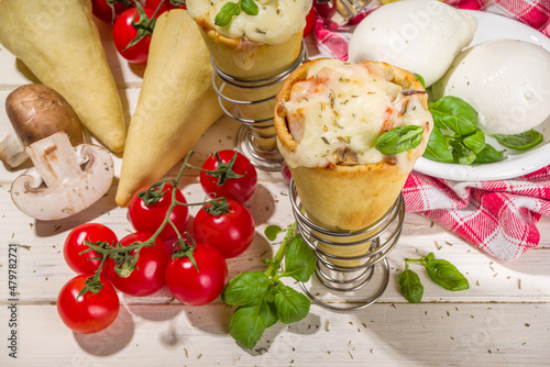 Trendy Cone pizza, modern pizza recipe, with tomatoes, basil, mozzarella cheese, baked pizza cones dough, ham and mushrooms