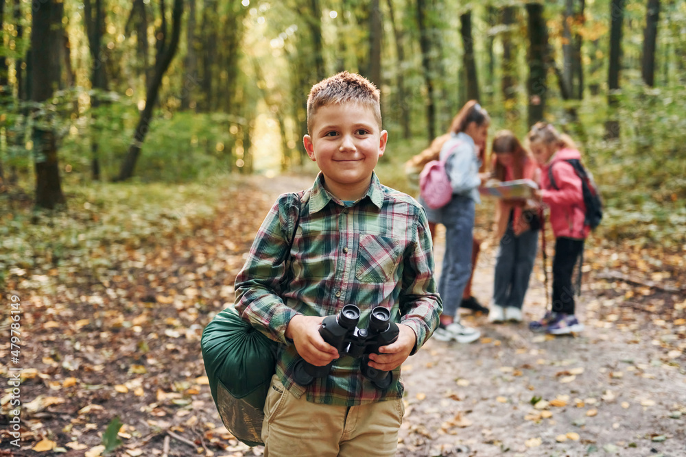 Conception of hiking. Kids in green forest at summer daytime together Conception of hiking. Kids in green forest at summer daytime together