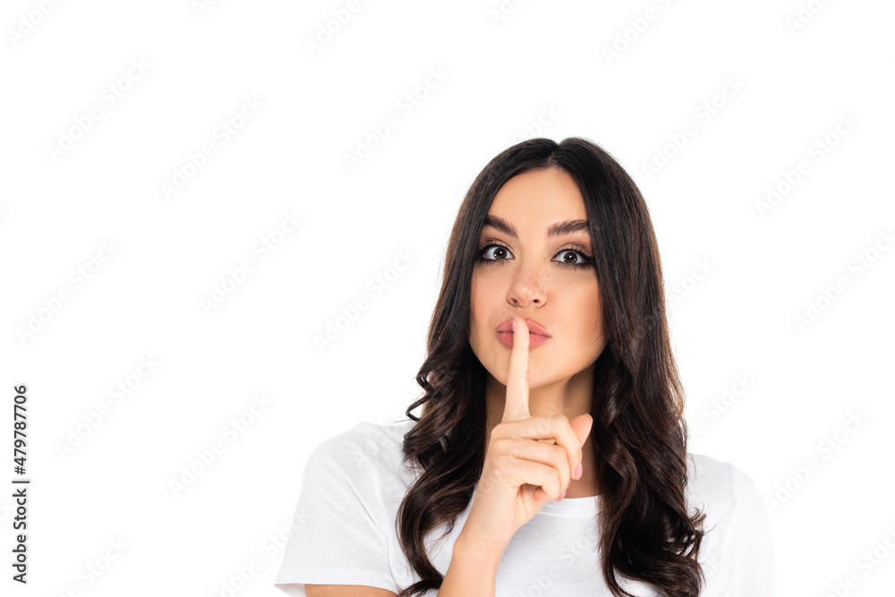 young brunette woman showing hush sign while looking at camera isolated on white. young brunette woman showing hush sign while looking at camera isolated on white.