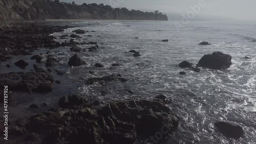 Small waves roll over the rocks on the California coast at sunset
