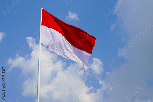 The single large red and white Indonesian flag flutters in the strong wind ahead of the 77th Independence Day of the Republic of Indonesia. photo