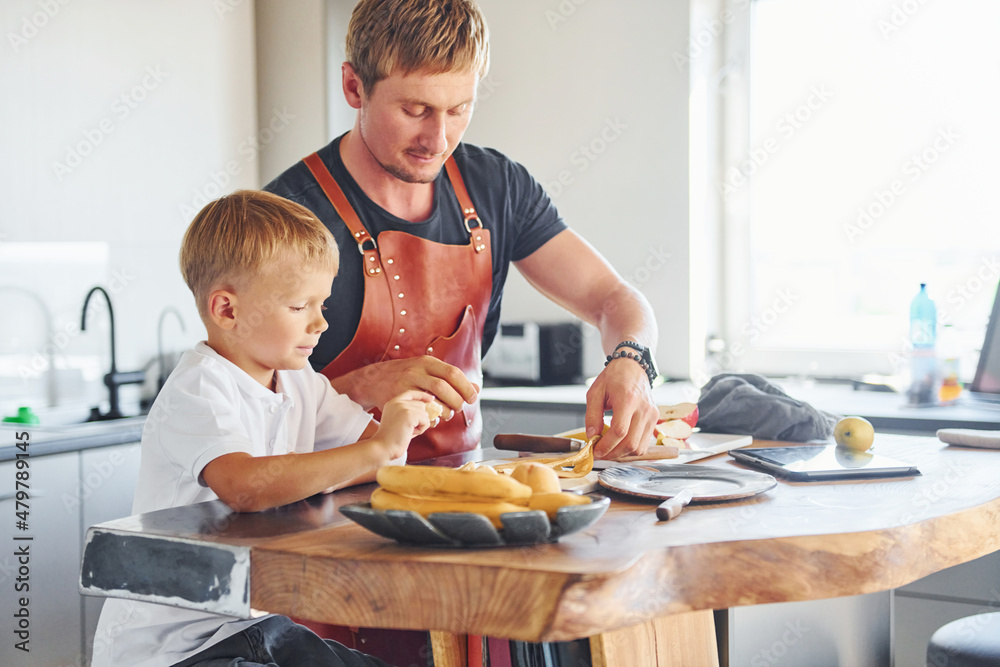 Conception of culinary. Father and son is indoors at home together Conception of culinary. Father and son is indoors at home together