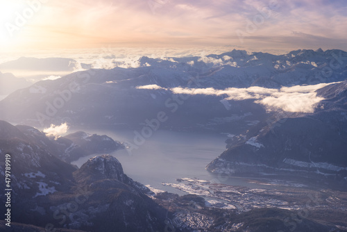 Aerial View of a small city, Squamish, in Howe Sound during winter season. Sunst Sky Art Render. Located north of Vancouver, British Columbia, Canada.