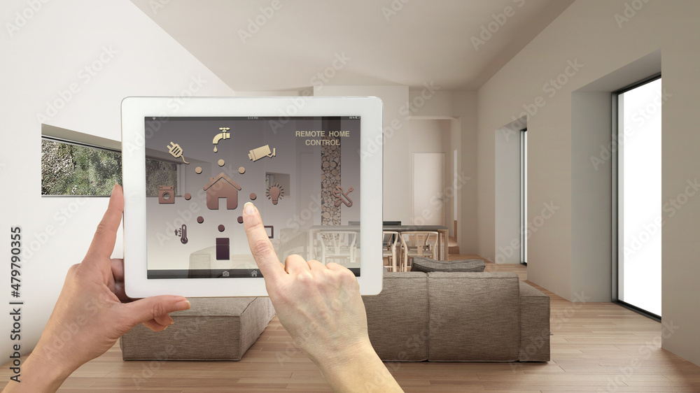 Smart remote home control system on a digital tablet. Device with app icons. Minimalist modern bright living room in the background, architecture interior design Smart remote home control system on a digital tablet. Device with app icons. Minimalist modern bright living room in the background, architecture interior design