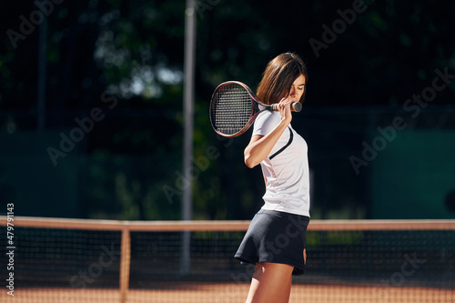 Female tennis player is on the court at daytime posing for a camera © standret