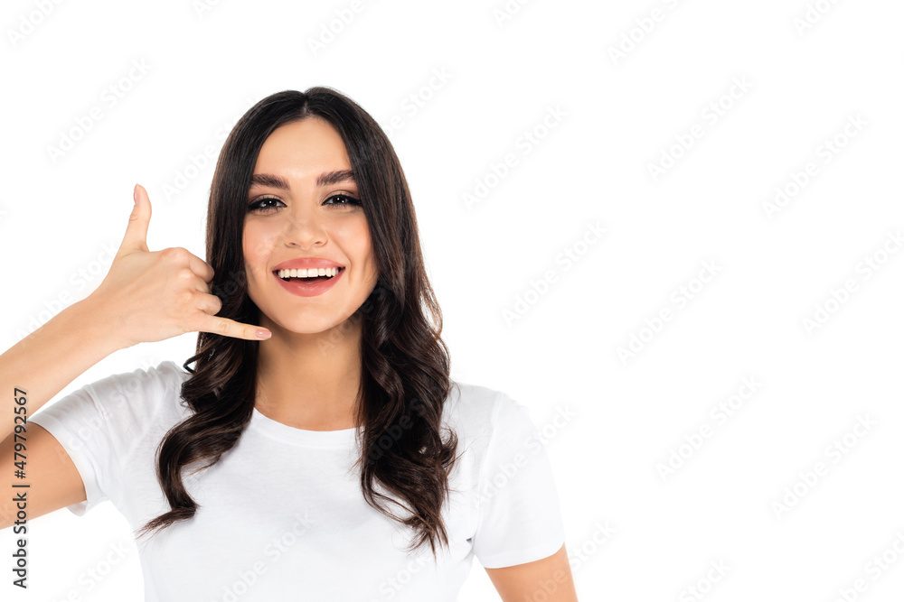 excited brunette woman showing call me gesture while looking at camera isolated on white. excited brunette woman showing call me gesture while looking at camera isolated on white.