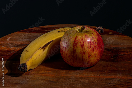 maçã vermelha e banana sobre um fundo de madeira photo