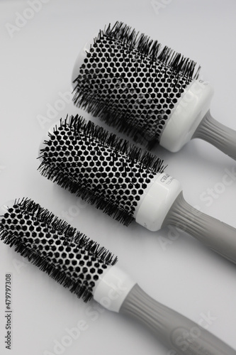 three round professional brushes of different sizes close-up on a light background