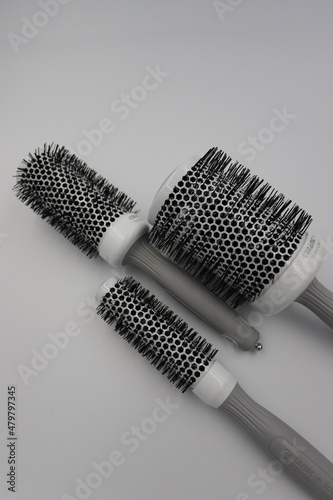 three round professional brushes of different sizes close-up on a light background