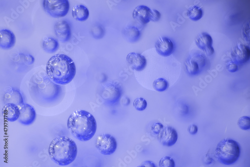 Abstract background. Texture. Many round bubbles of the shower gel on the blue background. Sometimes blurred bubbles. Trendy color. Color 2022. Color of the year. Very Peri.