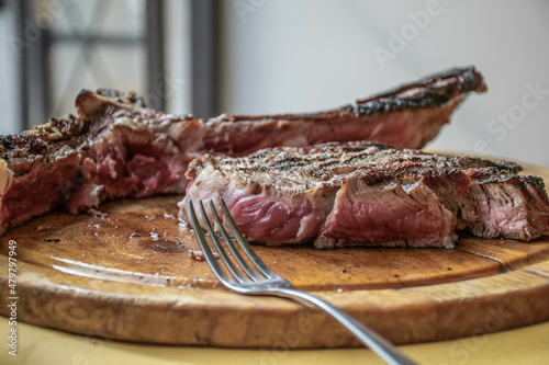 Obraz na plátně Pisa, Italy, September 2015, Cut florentine steak on a wooden cutting board clos