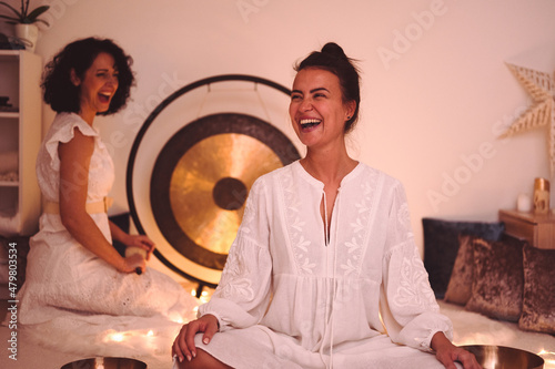Sound Healing Therapy with two beautiful and hard laughing women in low ambient light