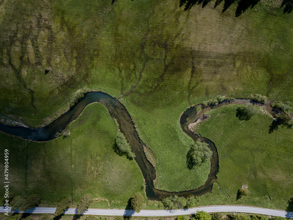 river flowing through green grass in the bavarian alps