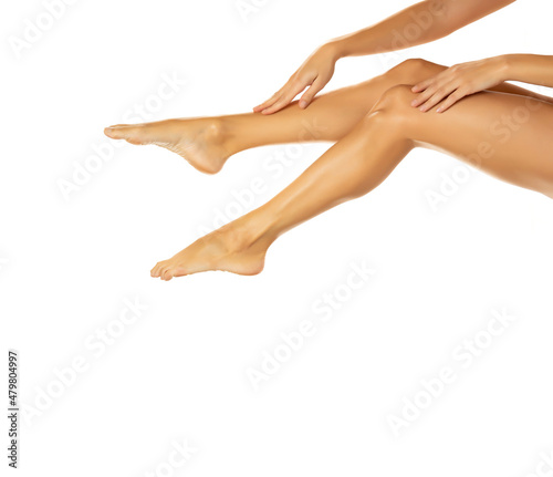 Partial view of slim young woman touching long smooth legs
