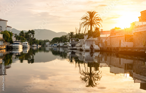 Fotografering View of the canals with boats moored in Empuriabrava, Spain at sunrise