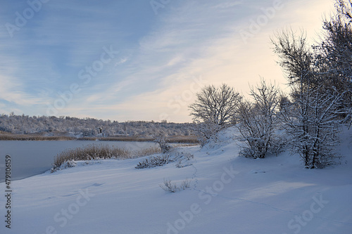 Winter landscape: lake shore after snowfall.