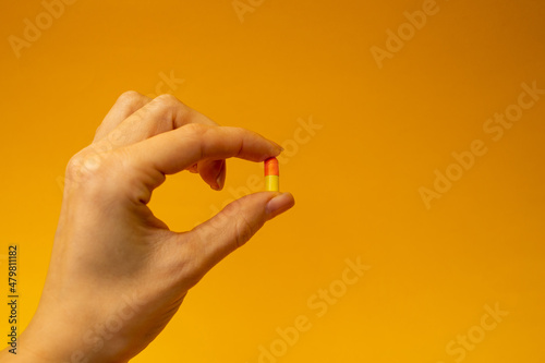 A girl holding a pill in her hand