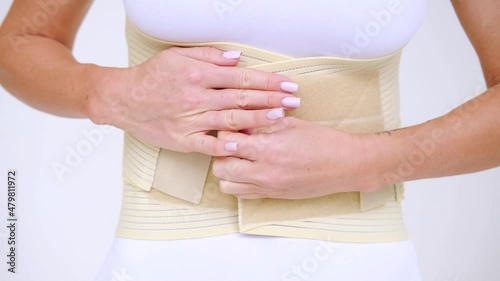 Wallpaper Mural Woman wearing beige support belt isolated on white. The girl fastens the belt Torontodigital.ca