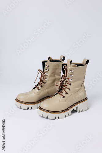Beautiful beige shoes with genuine leather on an isolated white studio background. Fashionable classic women's boots. Stylish elegant leather shoes.
